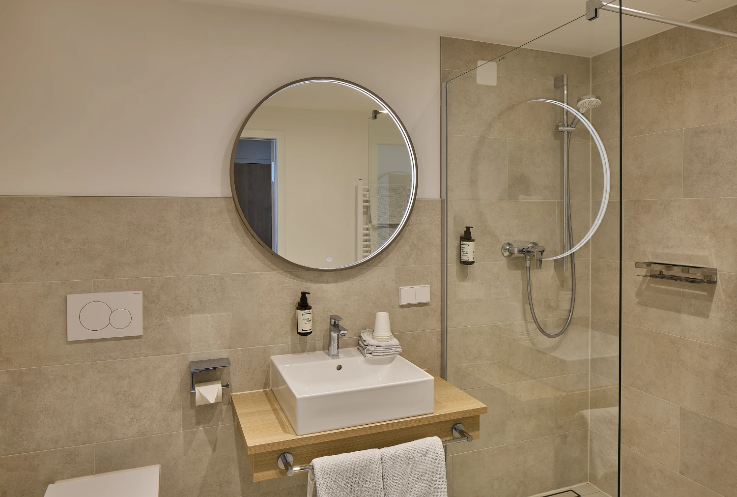 Helles und modernes Badezimmer mit Waschebecken, Dusche und Toilette