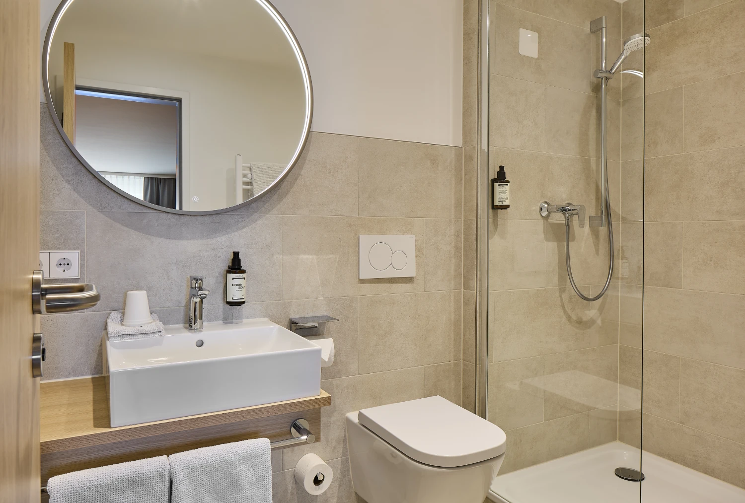 Helles und modernes Badezimmer mit Waschebecken, Dusche und Toilette