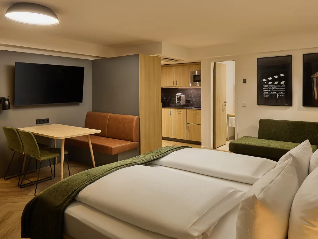 Modernes Hotelzimmer Apparment mit Doppelbett, Sitzecke, Küchenzeile und Sofa.