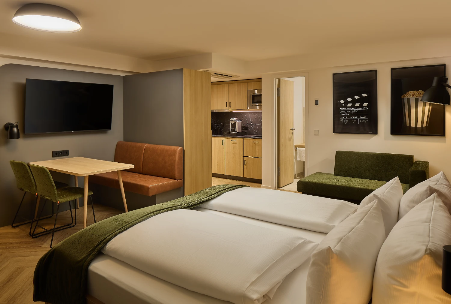 Modernes Hotelzimmer Apparment mit Doppelbett, Sitzecke, Küchenzeile und Sofa.