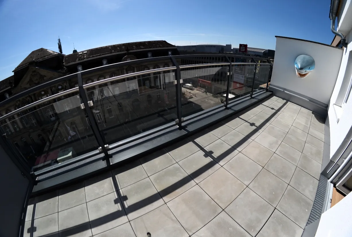 Großer Balkon mit Glasgeländer und Blick auf das Stadtzentrum