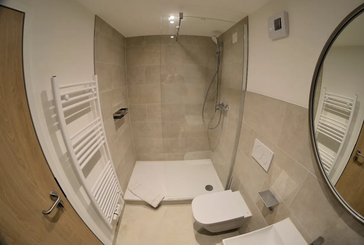 Begehbare Dusche und WC im modernen Badezimmer des Dreibettzimmers
