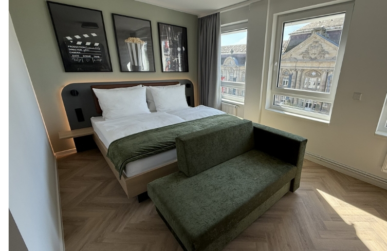 Doppelzimmer mit Sofa und großem Fenster mit Blick auf die Postgalerie