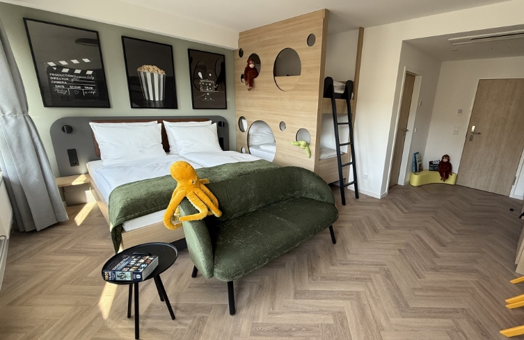 Familienzimmer mit verspieltem Design, Kino-Dekoration und Stofftier für Kinder