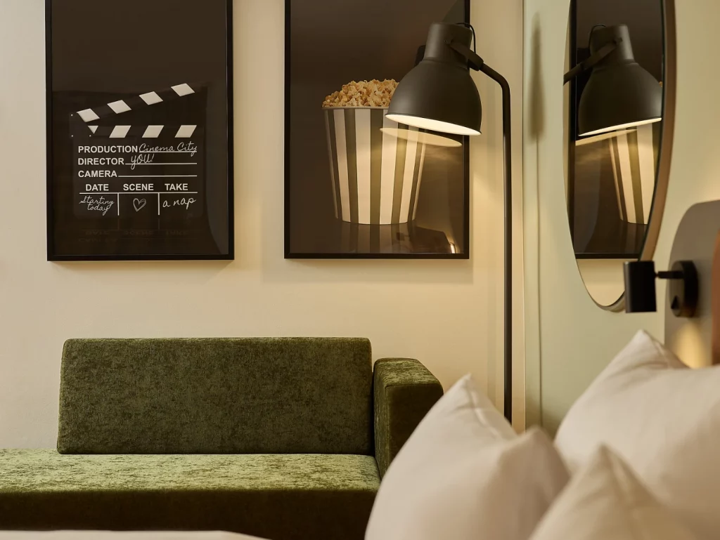 Detailaufnahme des Hotelzimmers mit Couch, Lampe und Wandbildern